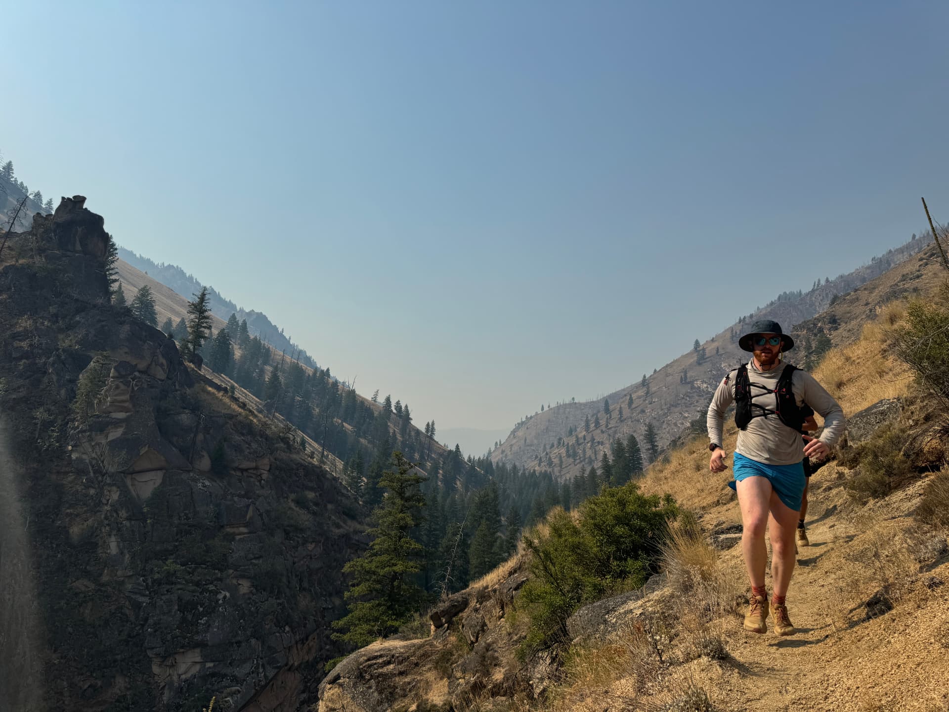 Ben Christensen running a forested mountain trail